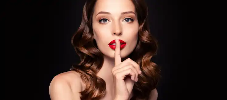  well-dressed woman making a &quot;shhhhhh&quot; sign