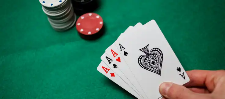 poker hand with 4 aces and chips on the table